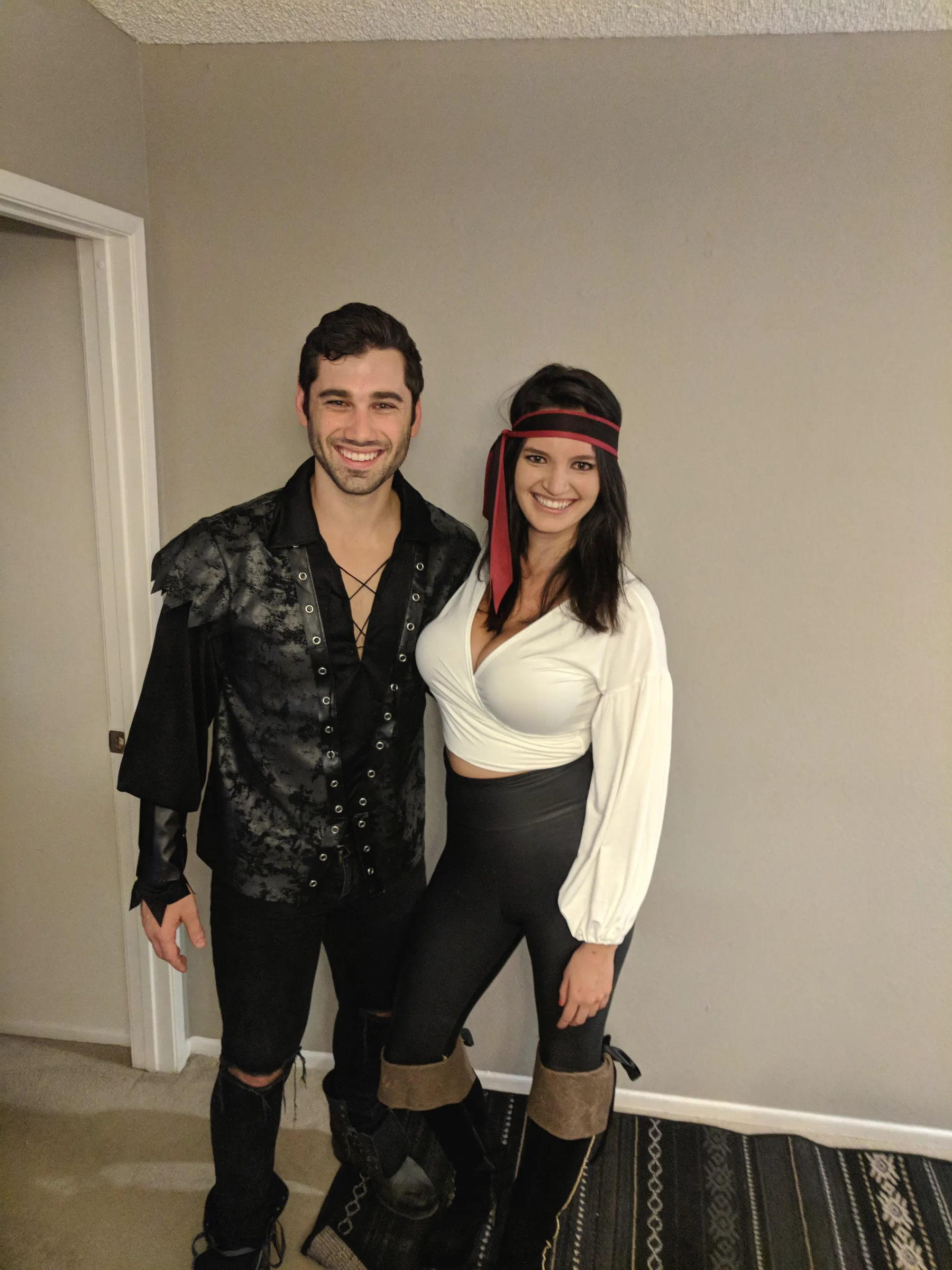 Charlie and Carmela in pirate costumes, Carmela with a red bandana, standing in a hallway